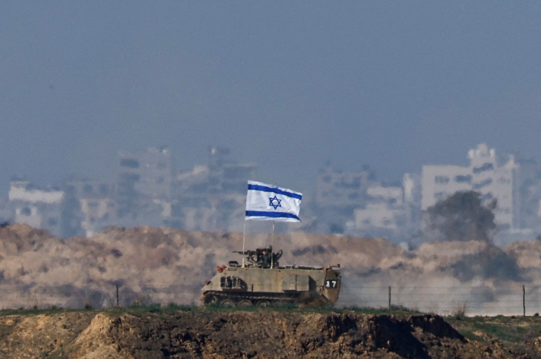 An Israeli military vehicle drives along the border with Gaza, amid the ongoing conflict between Israel and the Palestinian Islamist group Hamas, as seen from southern Israel